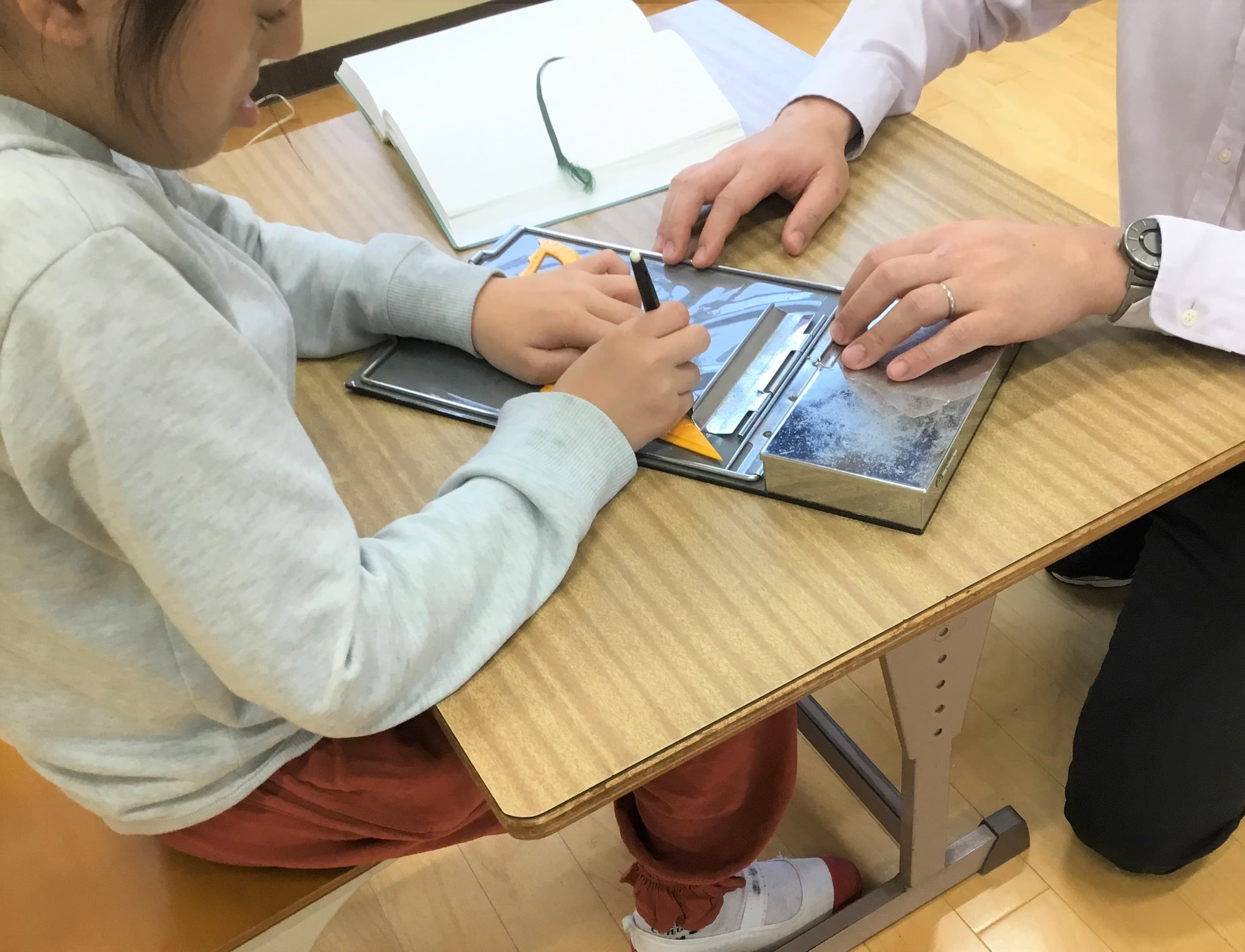 小学部４年生の児童が、レーズライターと三角定規、分度器を使って、三角形の作図をしている様子
