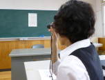 写真 単眼鏡を使用している様子。